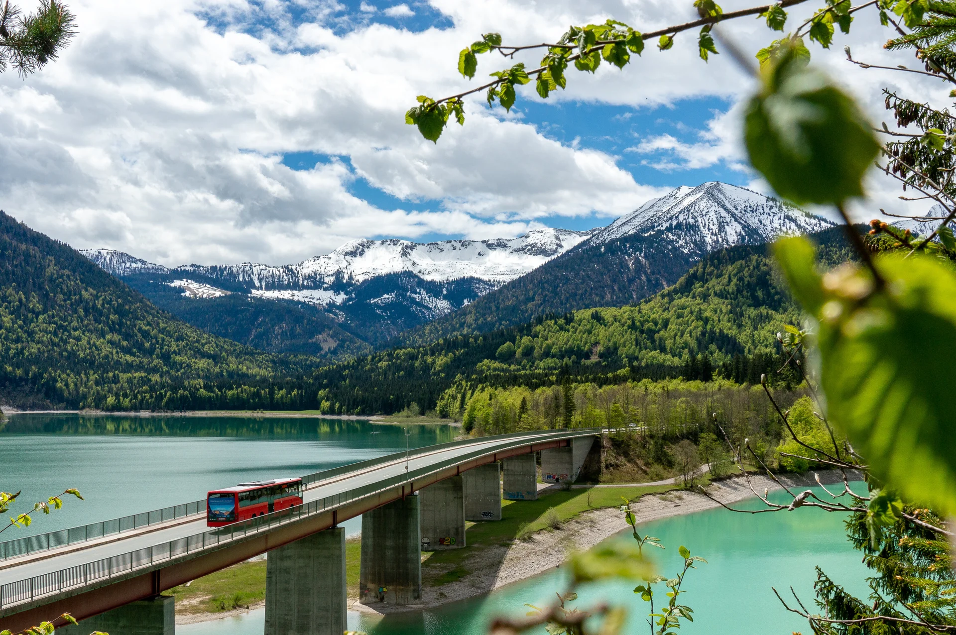 Bergbus | © DAV/Tobias Hipp Der Bergbus des Deutschen Alpemvereins fährt über eine Brücke in die Alpen | © DAV/Tobias Hipp